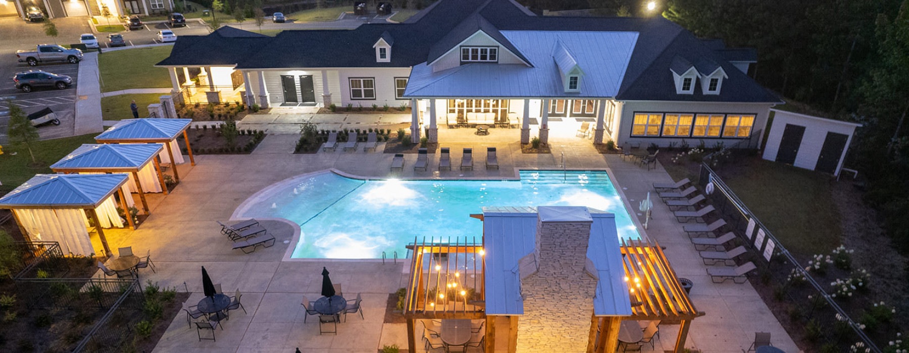 lighted clubhouse, pool and grill area at night in lagrange apartments